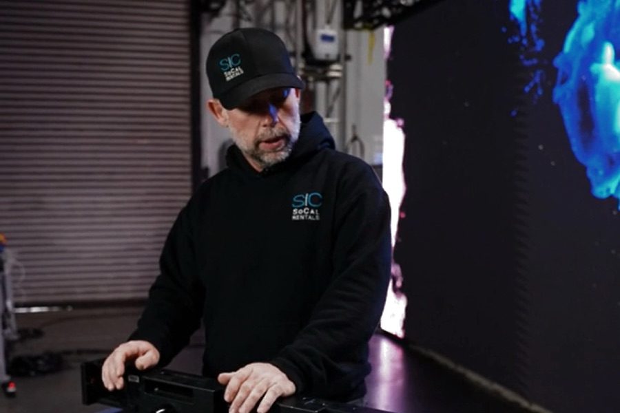 SoCal Rentals technician assembling LED tiles in front of an LED video wall